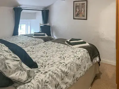 a bedroom with two beds with pillows on them at Ingle Neuk Cottage in Mosedale