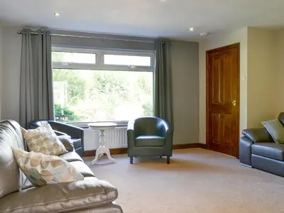 a living room with a couch and chairs and a window at Briar Rigg in Keswick