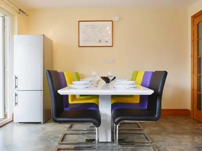 a dining room with a white table and chairs at Briar Rigg in Keswick
