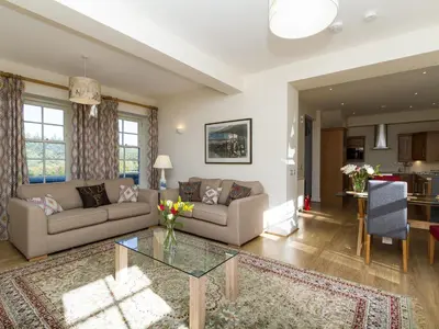 a living room with a couch and a table at Two The Stables in Dalrymple
