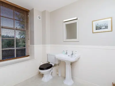 a white bathroom with a toilet and a sink at One The Stables in Dalrymple