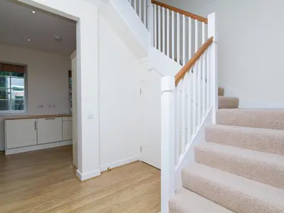 a staircase in a home with white walls and wood floors at One The Stables in Dalrymple