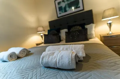 a bedroom with a bed with towels on it at Church View Irene Court Cockermouth in Cockermouth