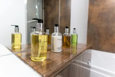 a group of bottles of oils sitting on a counter in a bathroom at Irene Court Cockermouth in Cockermouth