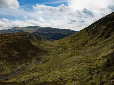 a view of a mountain valley with a river at Culsharg Cottage in Bargrennan