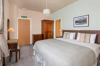 a bedroom with a large bed and a desk at Sharp Edge in Penrith