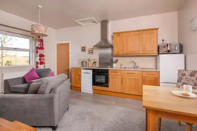 a living room with a couch and a kitchen at Sharp Edge in Penrith