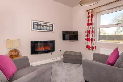 a living room with two couches and a fireplace at Sharp Edge in Penrith