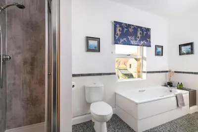 a bathroom with a toilet and a tub and a sink at Sharp Edge in Penrith