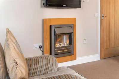 a fireplace in the corner of a living room at Bannerdale in Penrith