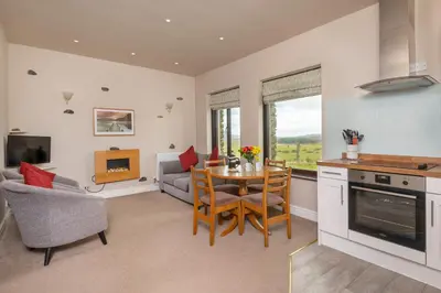 a kitchen and living room with a table and chairs at Grisdale View in Penrith