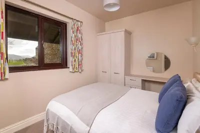 a bedroom with a bed and a window at Grisdale View in Penrith