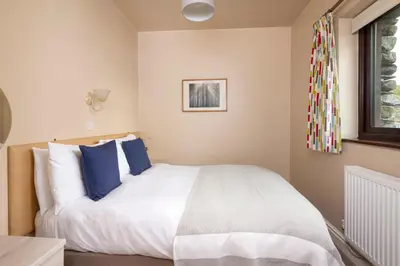 a bedroom with a large white bed with blue pillows at Howe Top in Mungrisdale