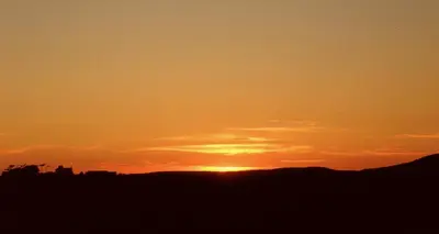 a sunset with the sun setting in the background at Cairndoon Byre in Monreith