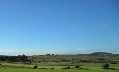 a green field with hills in the distance at Cairndoon Byre in Monreith