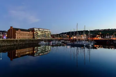 a marina with boats in the water at night at The Mansion in Whitehaven