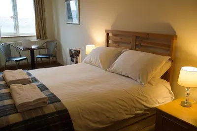 a bedroom with a bed and a table with chairs at The Mansion in Whitehaven