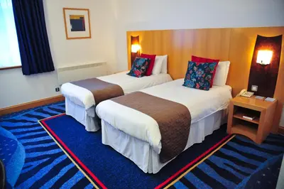 a hotel room with two beds and a table at The Park Hotel in Kilmarnock