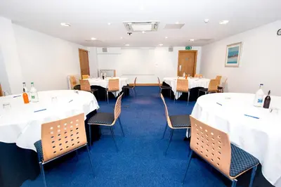 a dining room with white tables and chairs at The Park Hotel in Kilmarnock