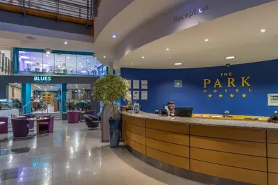 a lobby of a park hotel with a man sitting at a bar at The Park Hotel in Kilmarnock