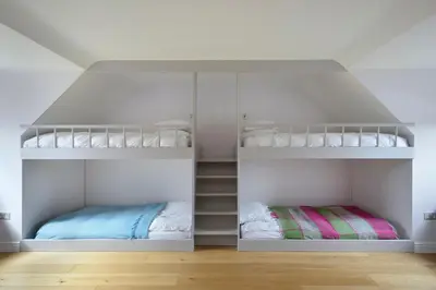 two bunk beds in a room with white walls at Airds Bay Luxury Beach House in Gatehouse of Fleet