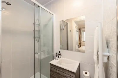 a white bathroom with a sink and a shower at Cragwood Guest House in Keswick