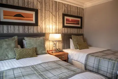 a hotel room with two beds and a lamp at Riverside Lodge Hotel in Irvine