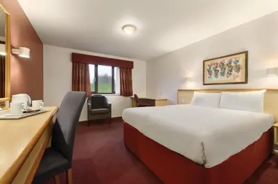 a hotel room with a large bed and a desk at Days Inn Hotel Gretna Green in Gretna Green