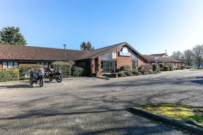 a motorcycle parked in a parking lot in front of a building at Days Inn Hotel Gretna Green in Gretna Green