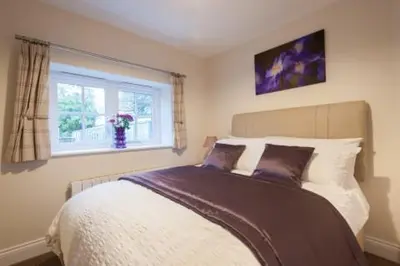 a bedroom with a bed and a window at Milntown Self Catering Apartments in Ramsey