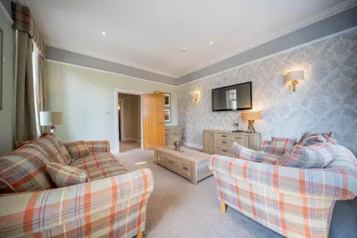 a living room with two couches and a tv at Tinto Hotel in Symington