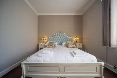 a bedroom with a large white bed with two lamps at Tinto Hotel in Symington