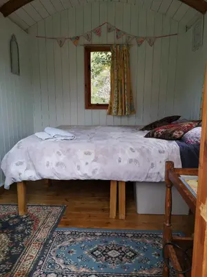 a bed in a room with a window at Stybeck Farm Shephards Hut in Thirlmere