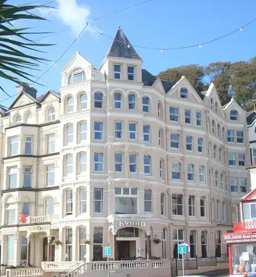a large white building on the corner of a street at The Hydro Hotel in Douglas