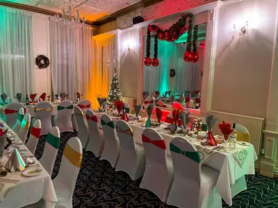 a banquet hall with tables and chairs and a christmas tree at The Hydro Hotel in Douglas