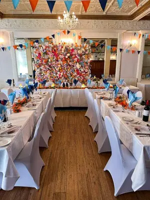 a large banquet hall with white tables and white chairs at The Hydro Hotel in Douglas