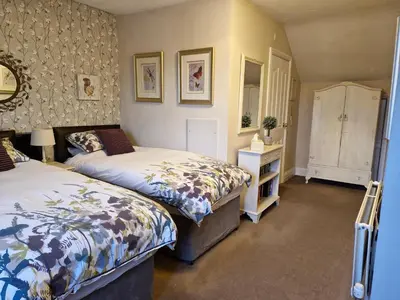 a bedroom with two beds and a dresser at Warwick Lodge in Carlisle