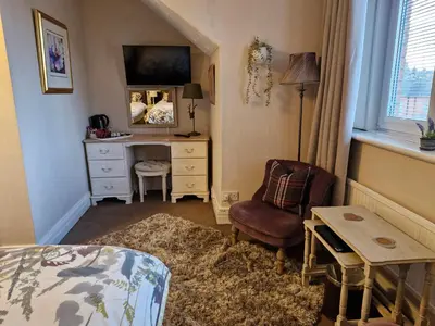 a bedroom with a desk and a chair at Warwick Lodge in Carlisle