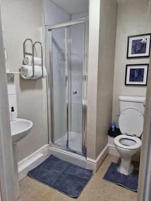 a bathroom with a shower and a toilet and a sink at Warwick Lodge in Carlisle