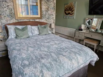 a bedroom with a large bed with a blue comforter at Warwick Lodge in Carlisle