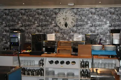 a clock on a wall in a coffee shop at Ascot Hotel in Douglas