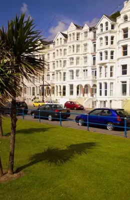 a palm tree in front of a large building at The Rutland Hotel in Douglas