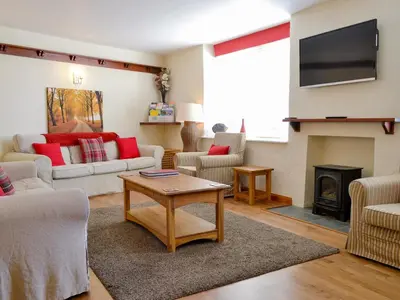 a living room with a couch and a fireplace at Rose Patch Cottage in Keswick