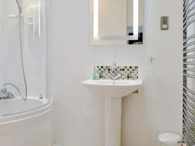 a white bathroom with a sink and a shower at Skiddaw in Keswick