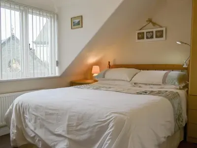 a bedroom with a white bed and a window at Blencathra in Keswick