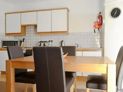 a kitchen with a wooden table and chairs at Cat Bells in Keswick