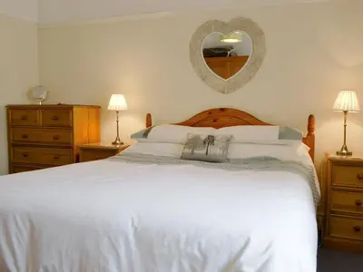 a bedroom with a large white bed and a mirror at Cat Bells in Keswick