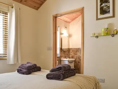 a bedroom with towels on a bed with a mirror at Larchwood in Ellonby