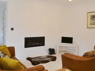 a living room with two couches and a fireplace at The Coach House in Grasmere