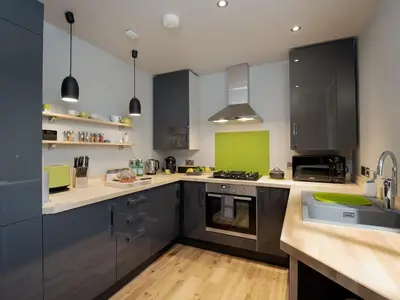 a kitchen with black and white cabinets and a sink at Granary in Gatehouse of Fleet